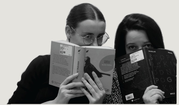 Le ragazze sbirciano curiose e giocose da dietro il libro.