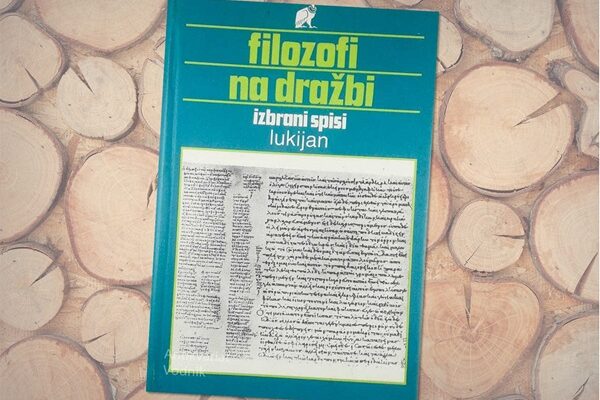 Zelenomodra naslovnica knjige na leseni podlagi.