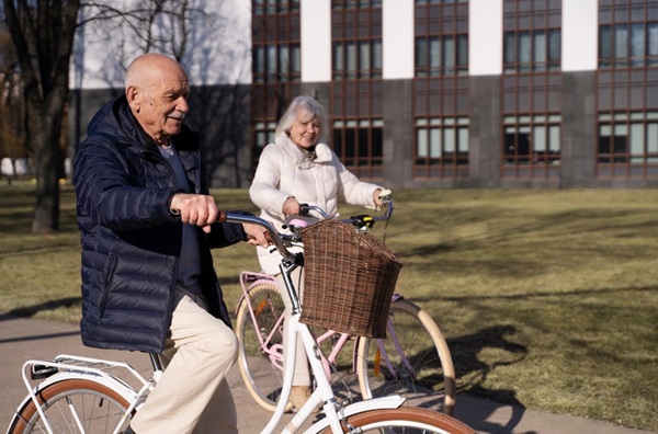 Una coppia di anziani in bicicletta.