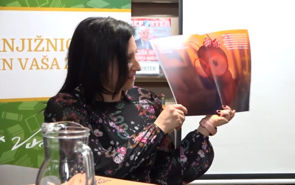 Una giovane donna mostra l’illustrazione di una formica durante la lettura di un albo illustrato per bambini.