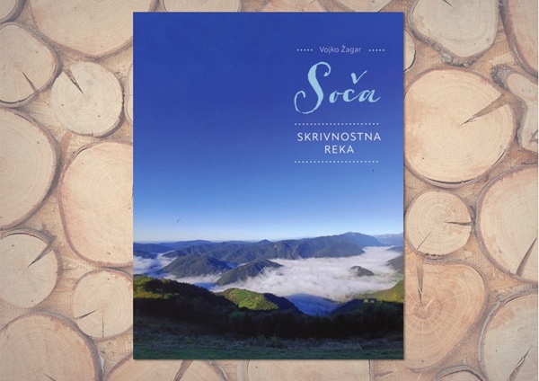 Naslovnica knjige Soča, skrivnostna reka avtorja Vojka Žagarja s fotografijo gorske pokrajine nad megleno dolino pod modrim nebom.